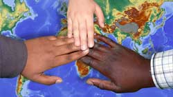 image about world charity. Multi-cultrual hands over a map of the world.